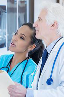 A nurse and a doctor going over an xray sheet in a hospital