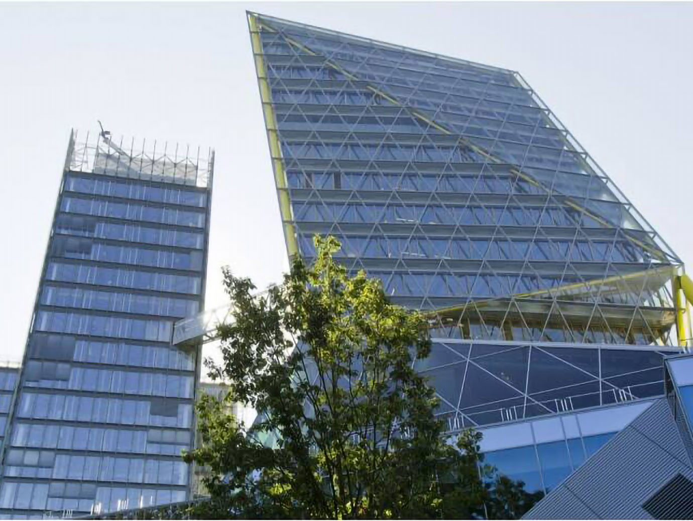 Upwards view of two glass buildings against the sky