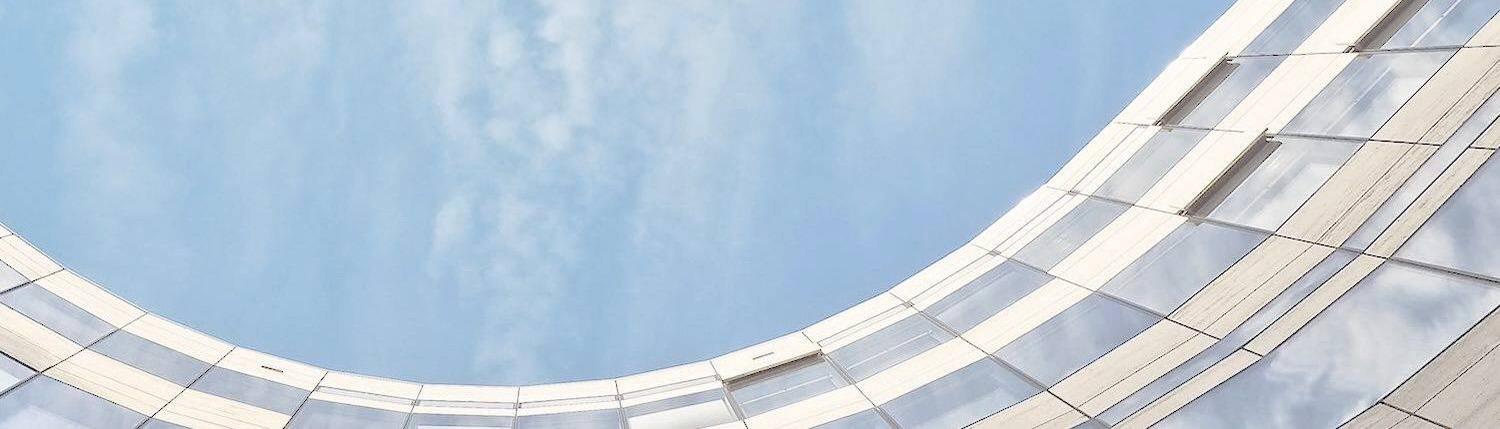 Close-up of a high-rise building with curved edge under the blue sky