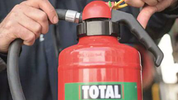 Close-up of a fire extinguisher as someone pulls out its pin