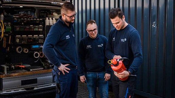Group of firefighters having a conversation while holding a total fire extinguisher