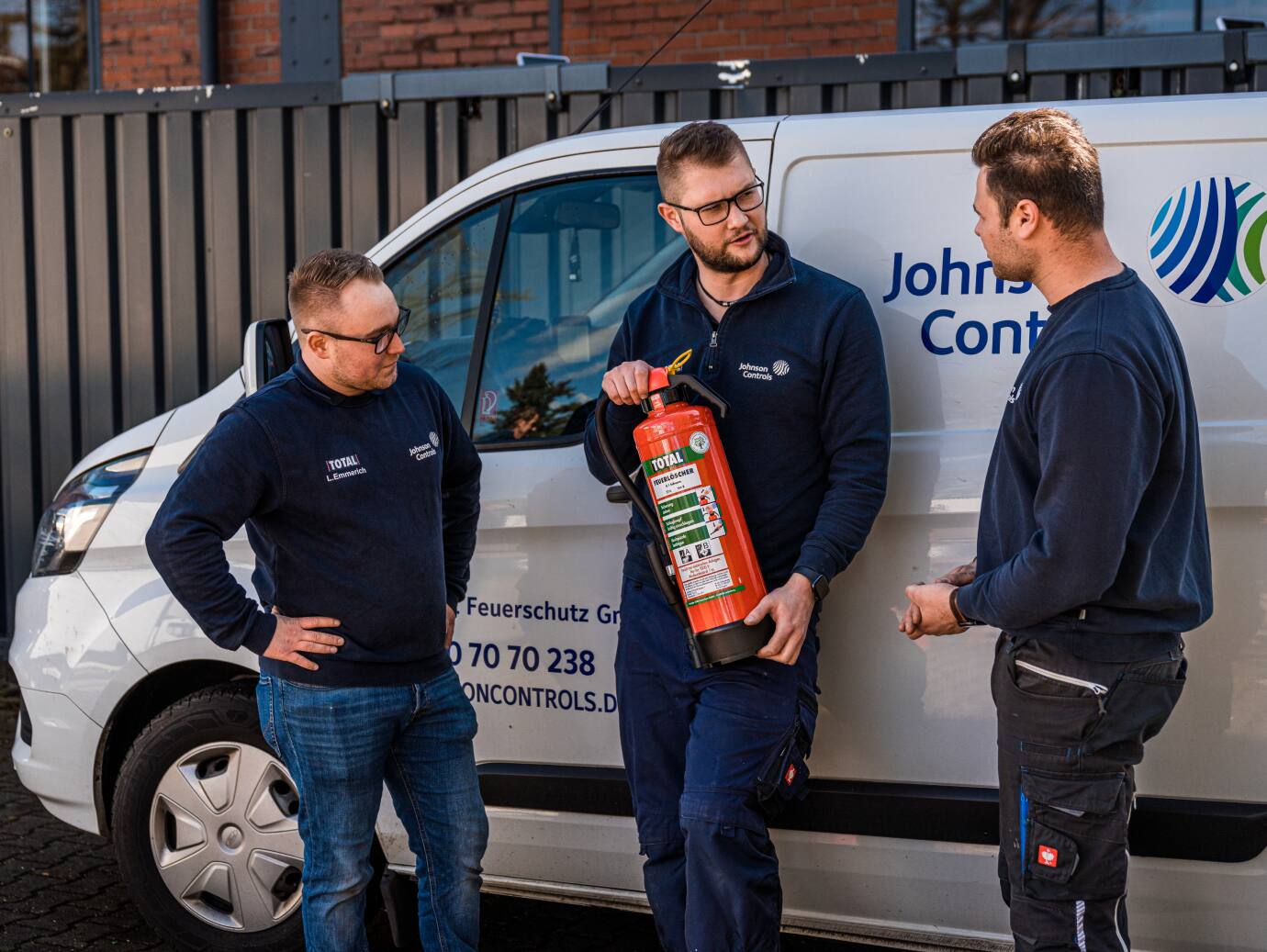 Group of firefighters having a conversation while holding a total fire extinguisher