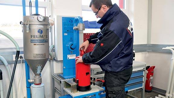 Firefighter refilling a fire extinguisher
