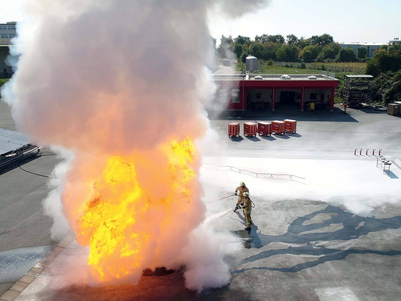 Firefighters dousing a flame in an outdoor space
