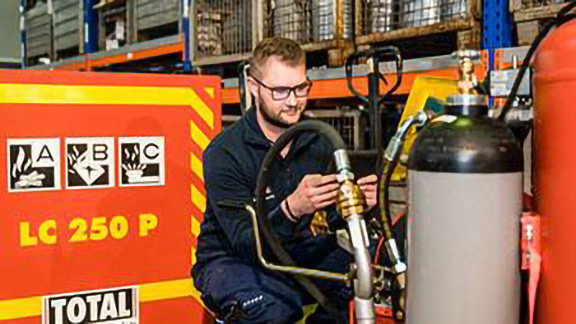 Firefighter inspecting a fire extinguisher