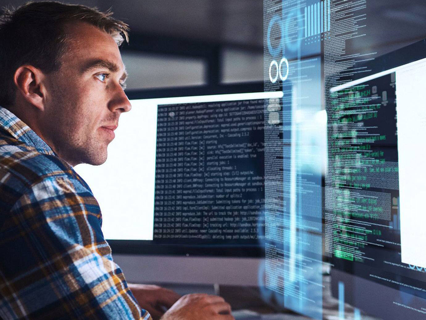 A man working on his laptop with codes being displayed on the screen