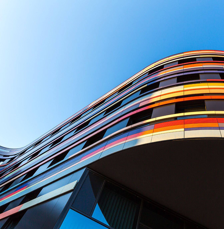 Upwards view of a curved, modern building against the sky