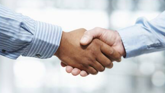Close-up shot of two men shaking hands