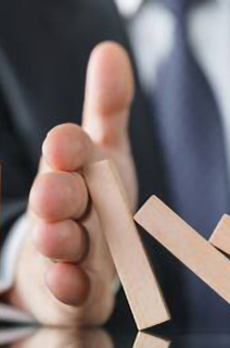 A person stopping building blocks from falling on the table