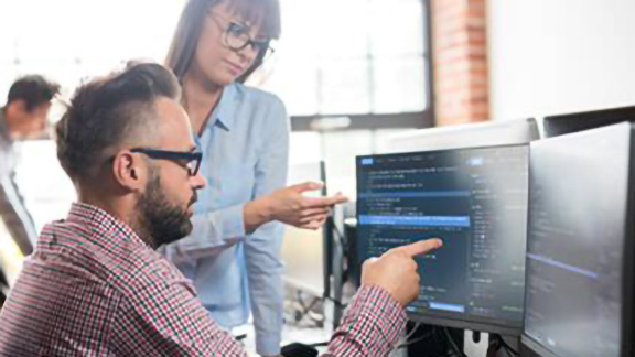 A male and a female colleague discussing work in their office