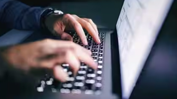 Close-up of a person working on his laptop
