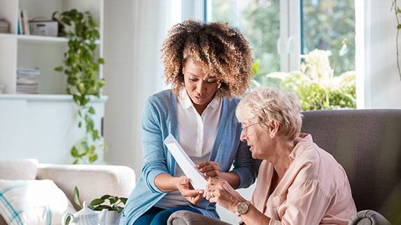 A caregiver talking to an elderly lady