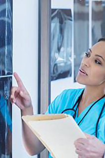 A doctor and a nurse analyzing an x-ray sheet