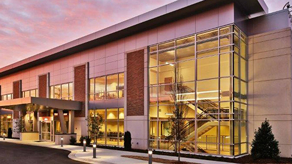 Exterior of a building with modern glass architecture during sunset