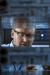 Two engineers inspecting a rack server cabinet in a data center
