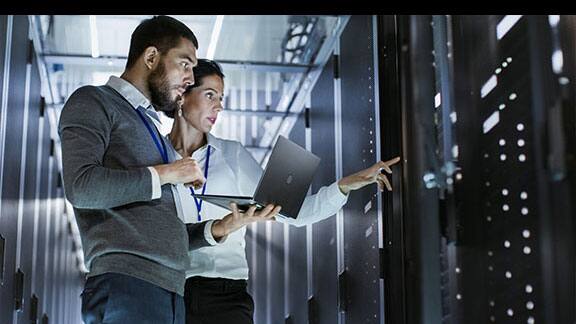 A man and a woman having a discussion in a data center