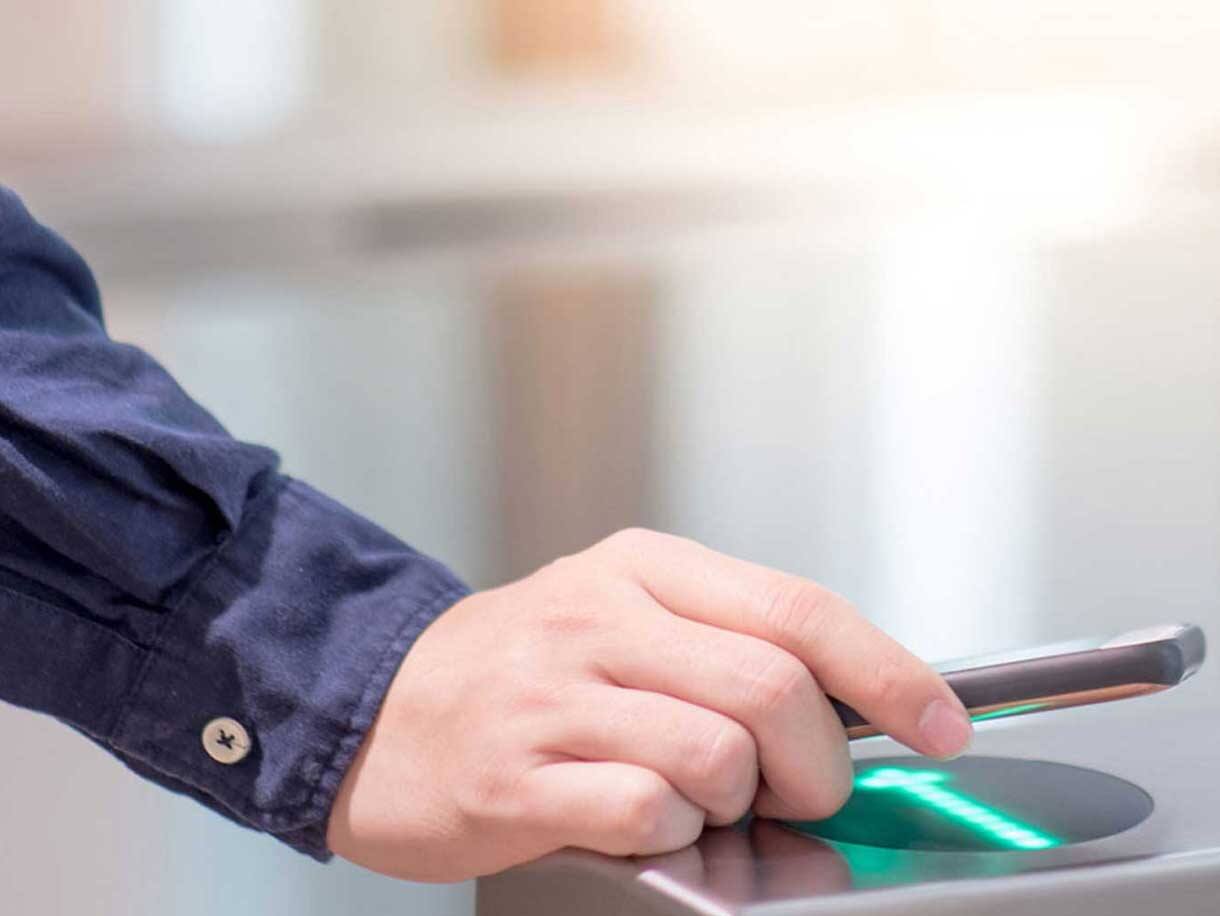 A man scanning his phone in an access control door