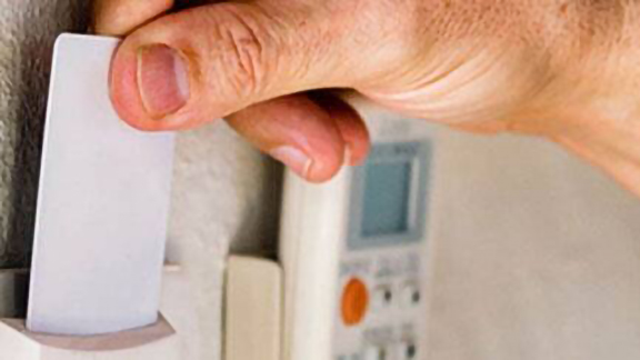 A person using a keyless entry card to enter his hotel room