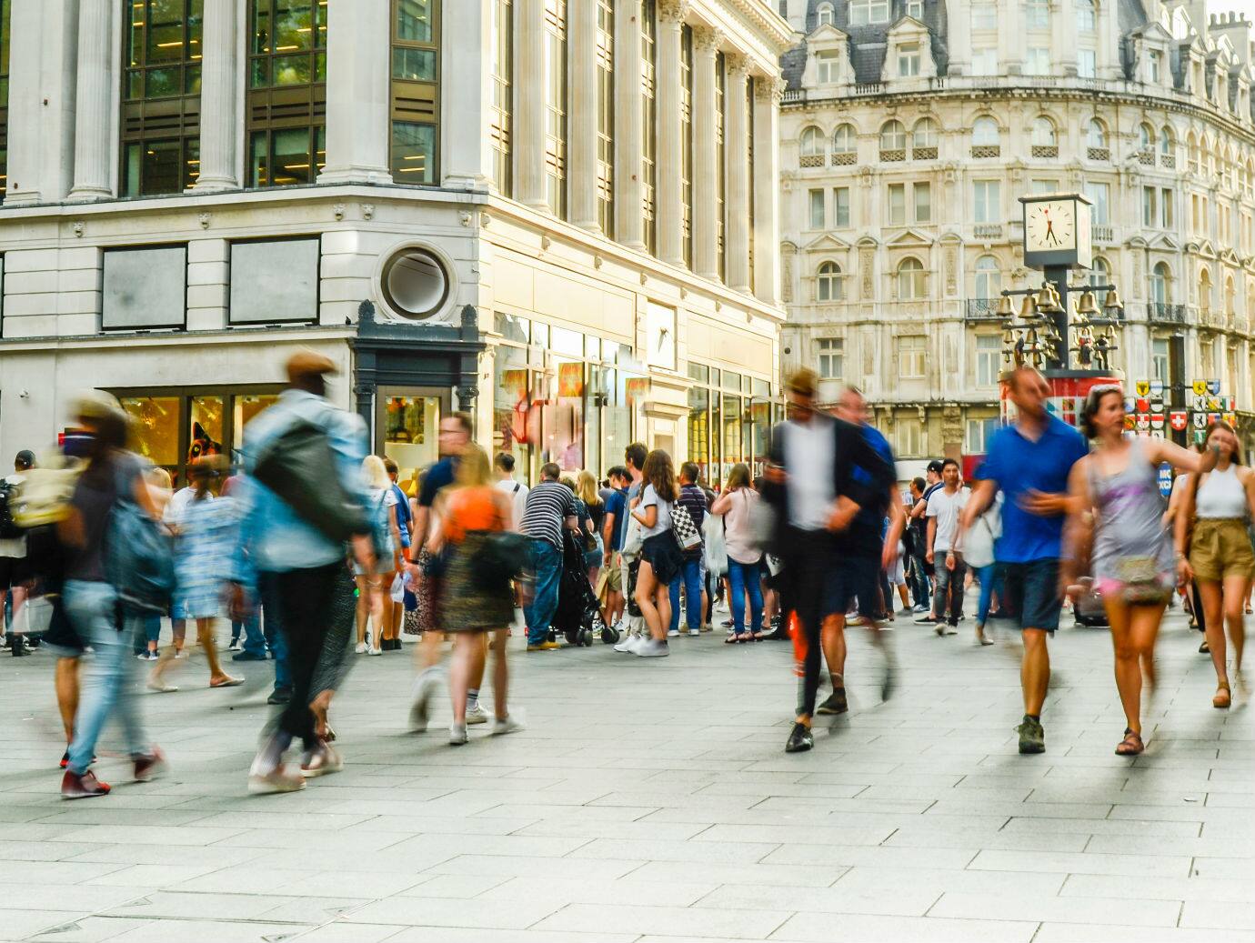 Motion blur image of people walking in a busy town square