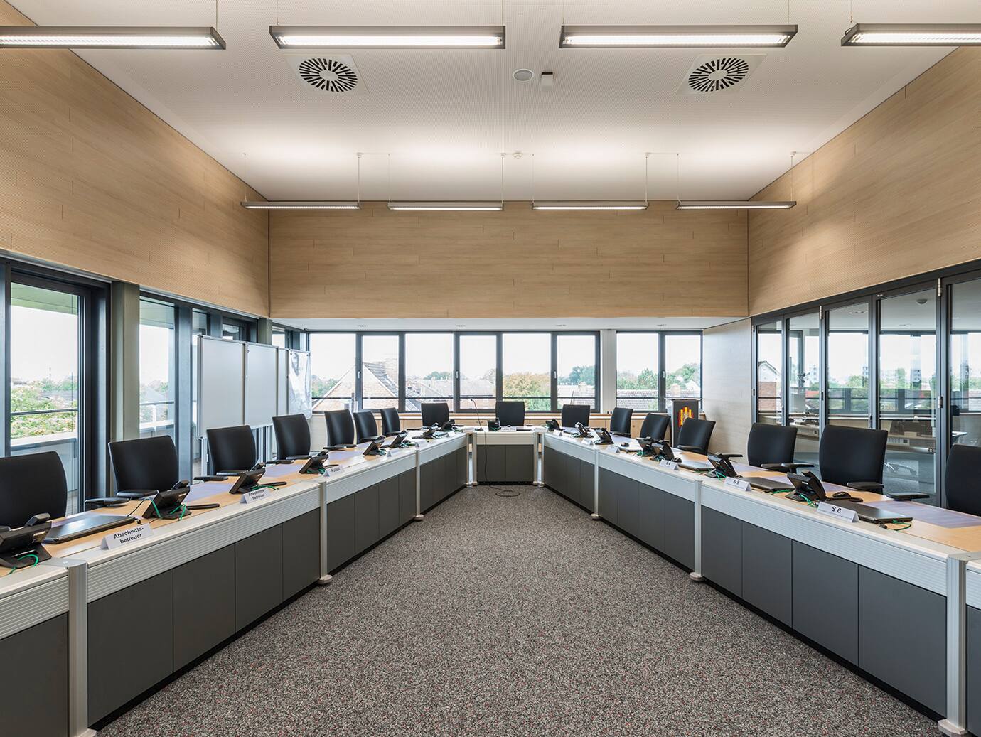 An empty conference room with chairs lined up in a row along desks