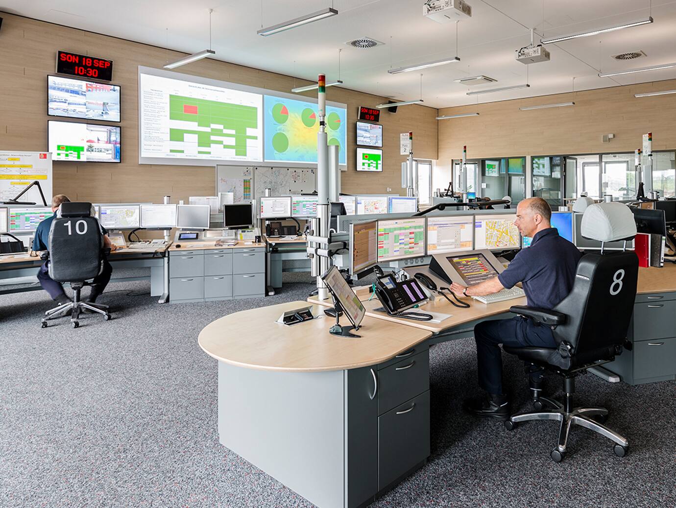 Two men at their desks in an ambulance dispatch centre