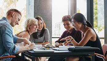Group of people discussing while sitting on a table