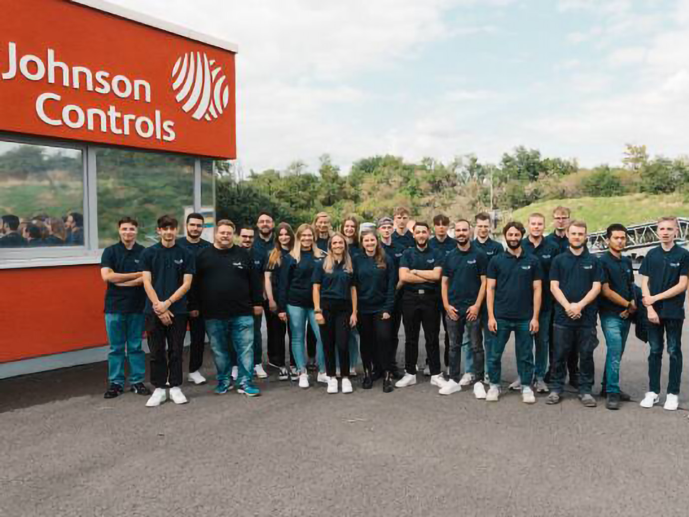 A group of employees smiling at the camera on the Johnson Controls office campus