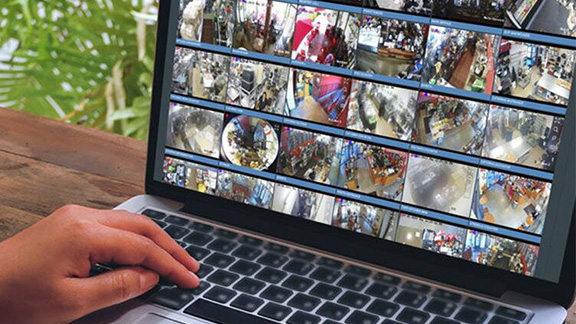 A man monitoring cctv footage on his laptop