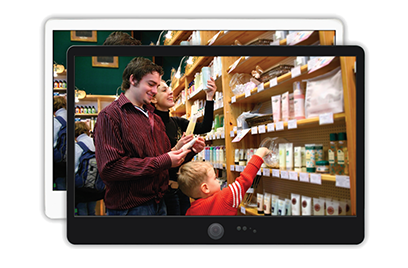 A family of parents with a their kid shopping at a mart is captured on a monitor