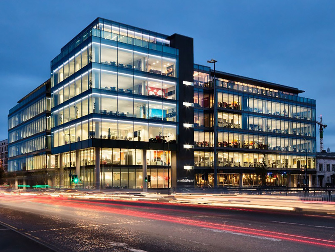 Johnson Controls One Albert Quay Office lit up at dusk