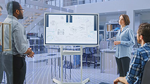 Employees in discussion at a meeting, with OpenBlue graphics overlaid in the background